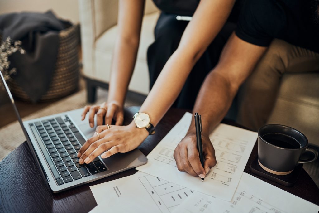 two people sit at a computer handling debt management in an effrort to reduce debt using amerant bank's tips