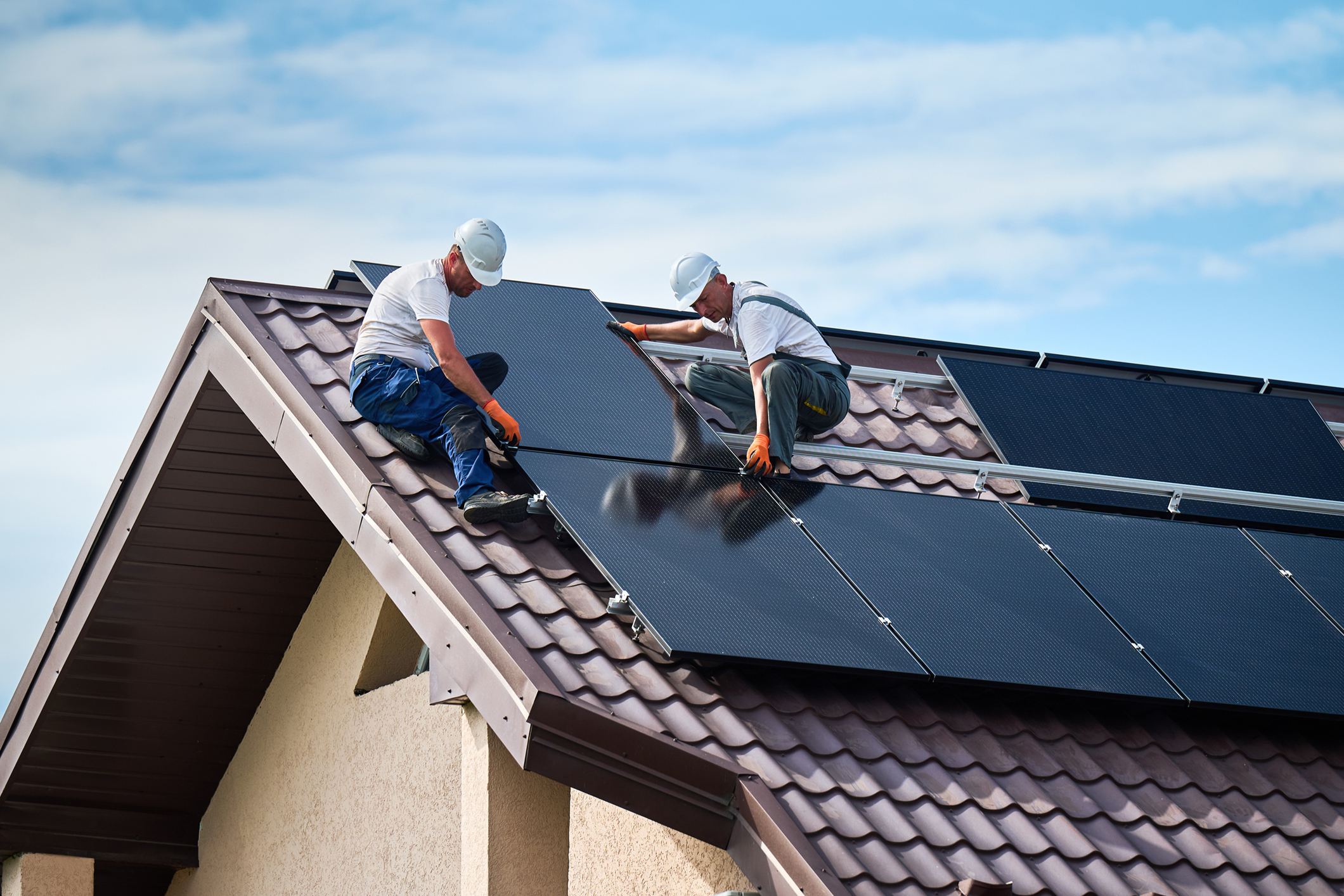 workers on roof installing solar panels