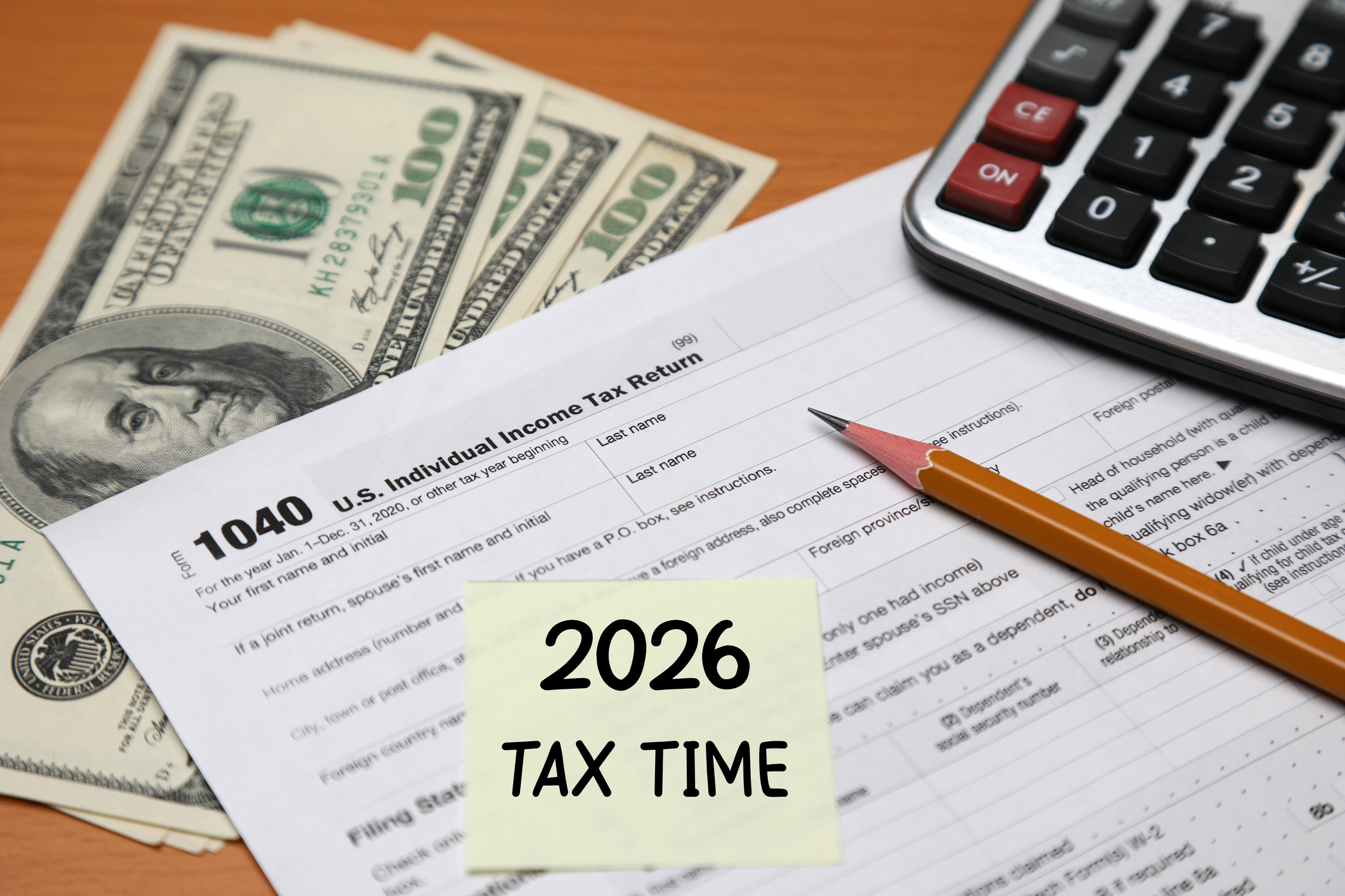 amerant bank dislays a tax form, cash, a pencil and a calculator with a post it note for tax day refund in 2026